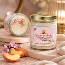 Jar of 'Sparkling Peach' scented soy candle with peach slices and flowers on a wooden surface.