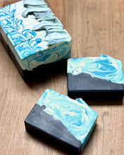 Marbled blue and white soap bars on a wooden surface