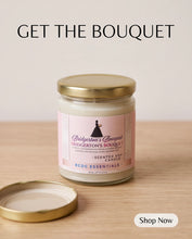 A glass jar candle with a pink label reading Bridgerton's Bouquet sits on a light wood surface with its gold lid placed beside it. Large text at the top says GET THE BOUQUET, and a white 'Shop Now' button appears in the lower right corner.