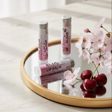 Lip balm tubes on a round mirror with cherry and flower decor