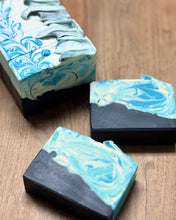 Marble-patterned soap bars with blue and white swirls on a wooden surface