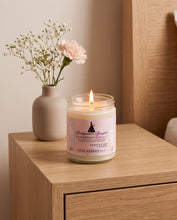 A lit glass jar candle sits on a light wood bedside table next to a beige vase with small white flowers. The candle label reads 'Bridgerton Receptions Scents' and 'Red Letter London.