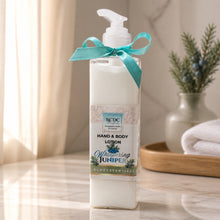 Hand and body lotion bottle with a teal ribbon on a wooden surface, blurred background