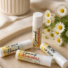 Four lip balm tubes with chamomile flavor on a beige surface with daisies in the background