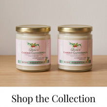 Two glass jars of 'Rena's Garden Gatherings' scented soy candles with gold lids and pink labels, displayed on a light wood surface against a neutral beige background, with a 'Shop the Collection' banner at the bottom.