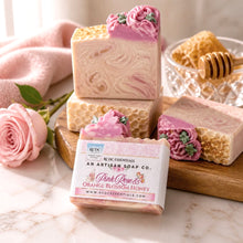 Decorative soap with floral design and a box labeled 'Pink Rose & Orange Blossom Honey' on a white background.
