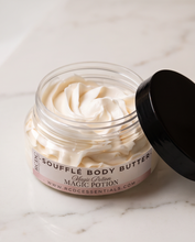 A jar of RCDC Sofflé Body Butter labeled 'Magic Potion' sits on a white marble bathroom counter,