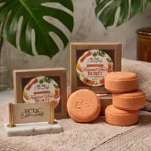 Three round orange solid shampoo bar labeled 'RCDC ESSENTIALS 
