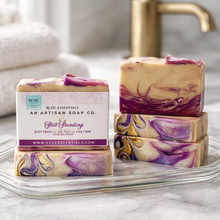 Stack of marbled soap bars with a box labeled 'An Artisan Soap Co.' on a marble surface.