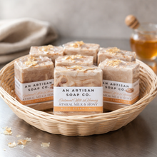 Bowl of An Artisan Soap Co. soap bars on a wooden surface with a neutral background