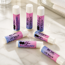 Various lip balms on a marble surface with a blurred background